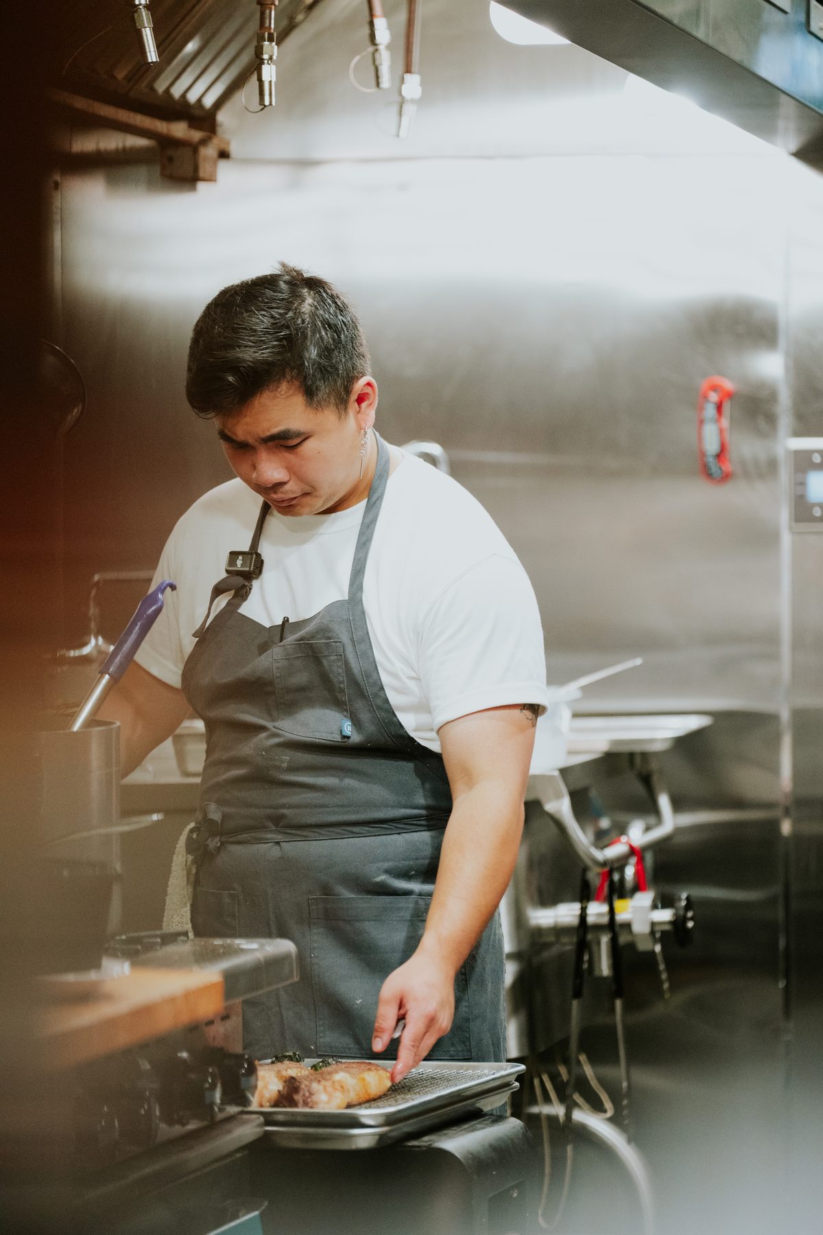 David Ho plating beef at the stove in the PhoXotic kitchen