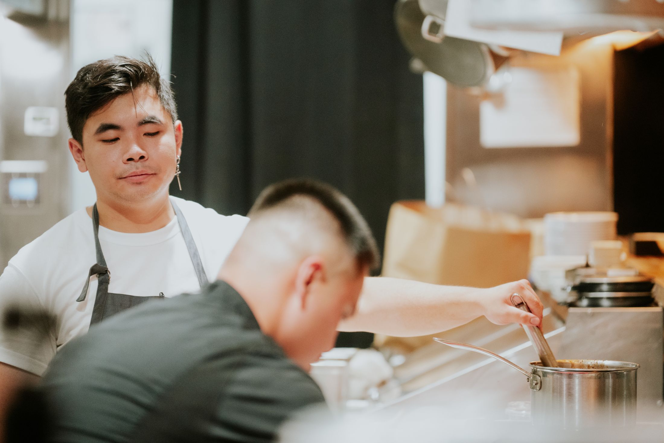 Two cooks working side by side at the pass