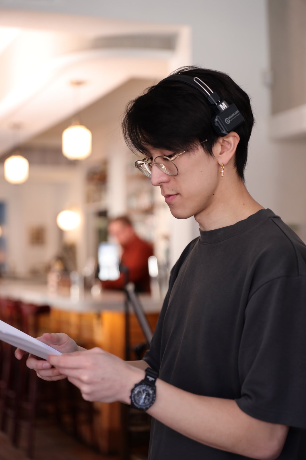 Sonny Tu reading the script on set at Dutch Courage, headphones on