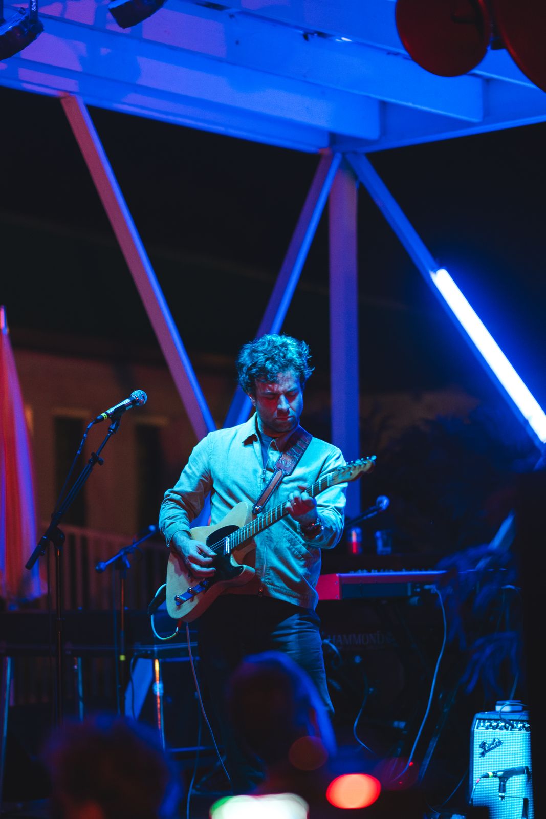 A guitarist singing under blue light in Nashville